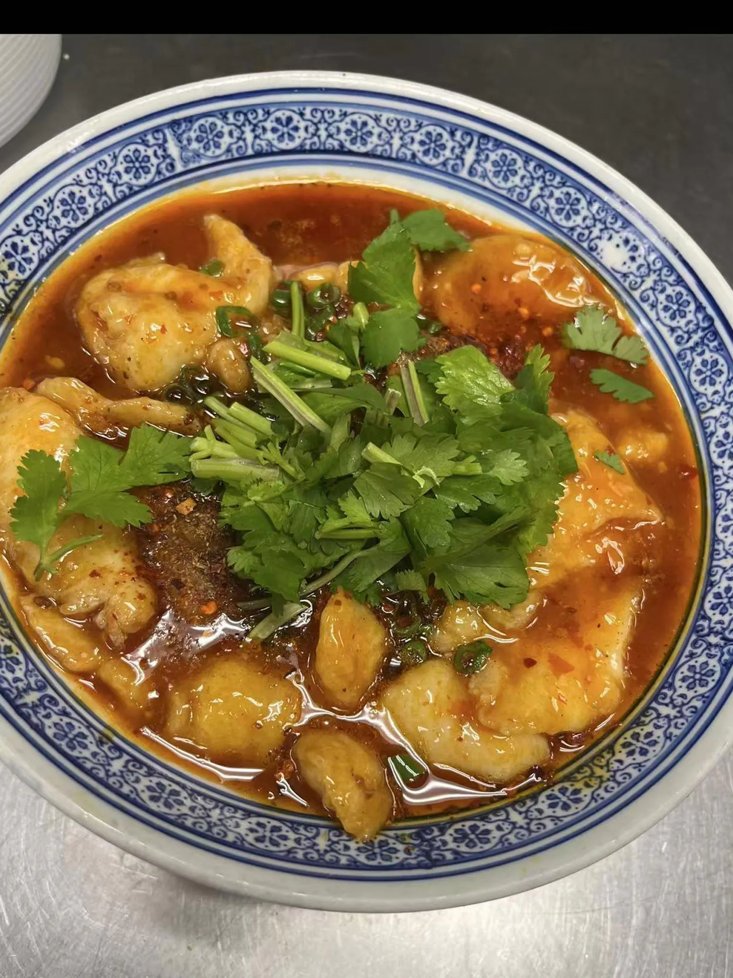 Spicy fish fillet in red chili oil broth garnished with cilantro at ShangWei Szechuan, a Chinese Restaurant in Bethlehem