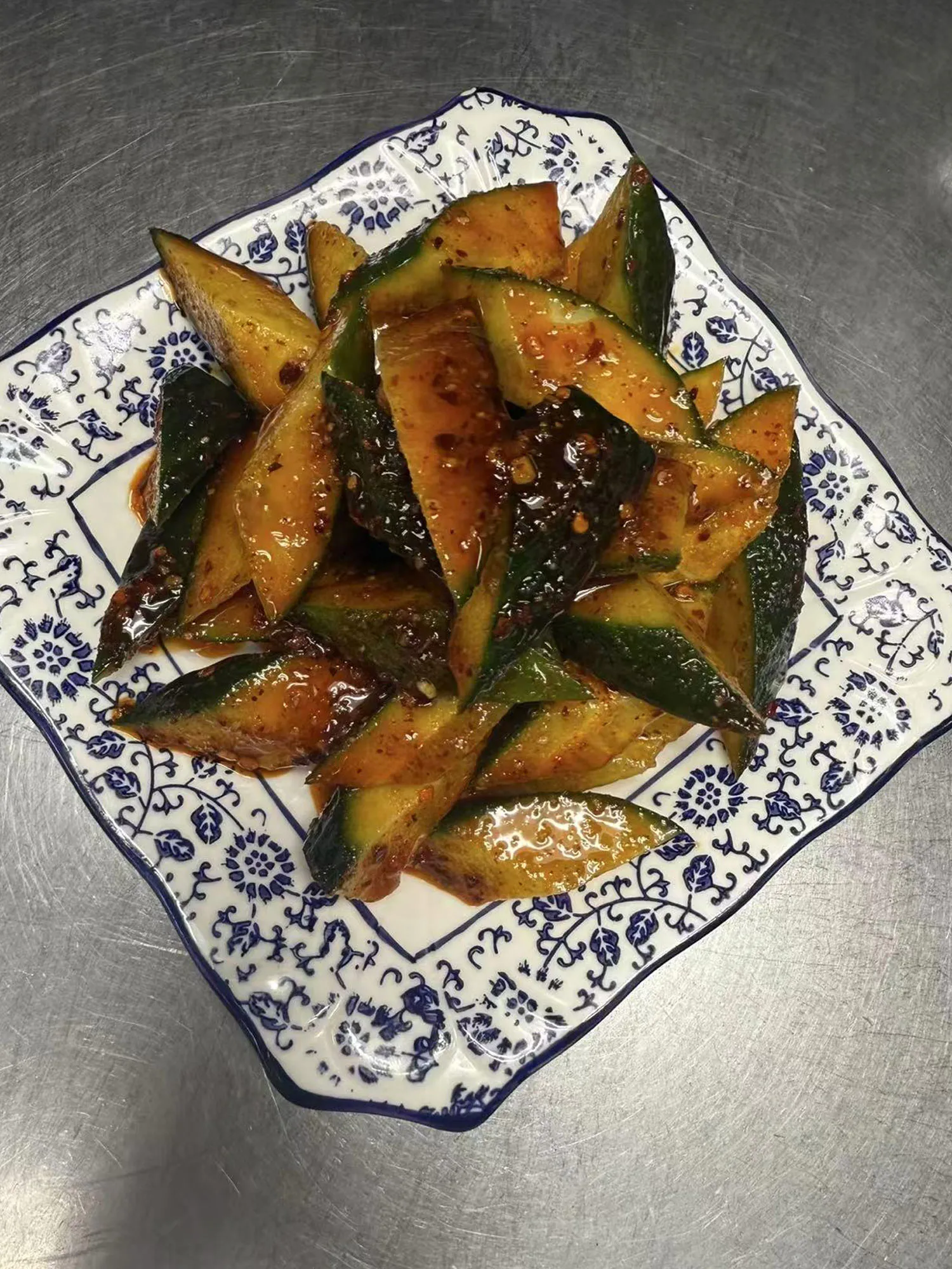Spicy cucumber salad tossed in chili garlic sauce on a patterned plate at ShangWei Szechuan, a Chinese Restaurant in Bethlehem