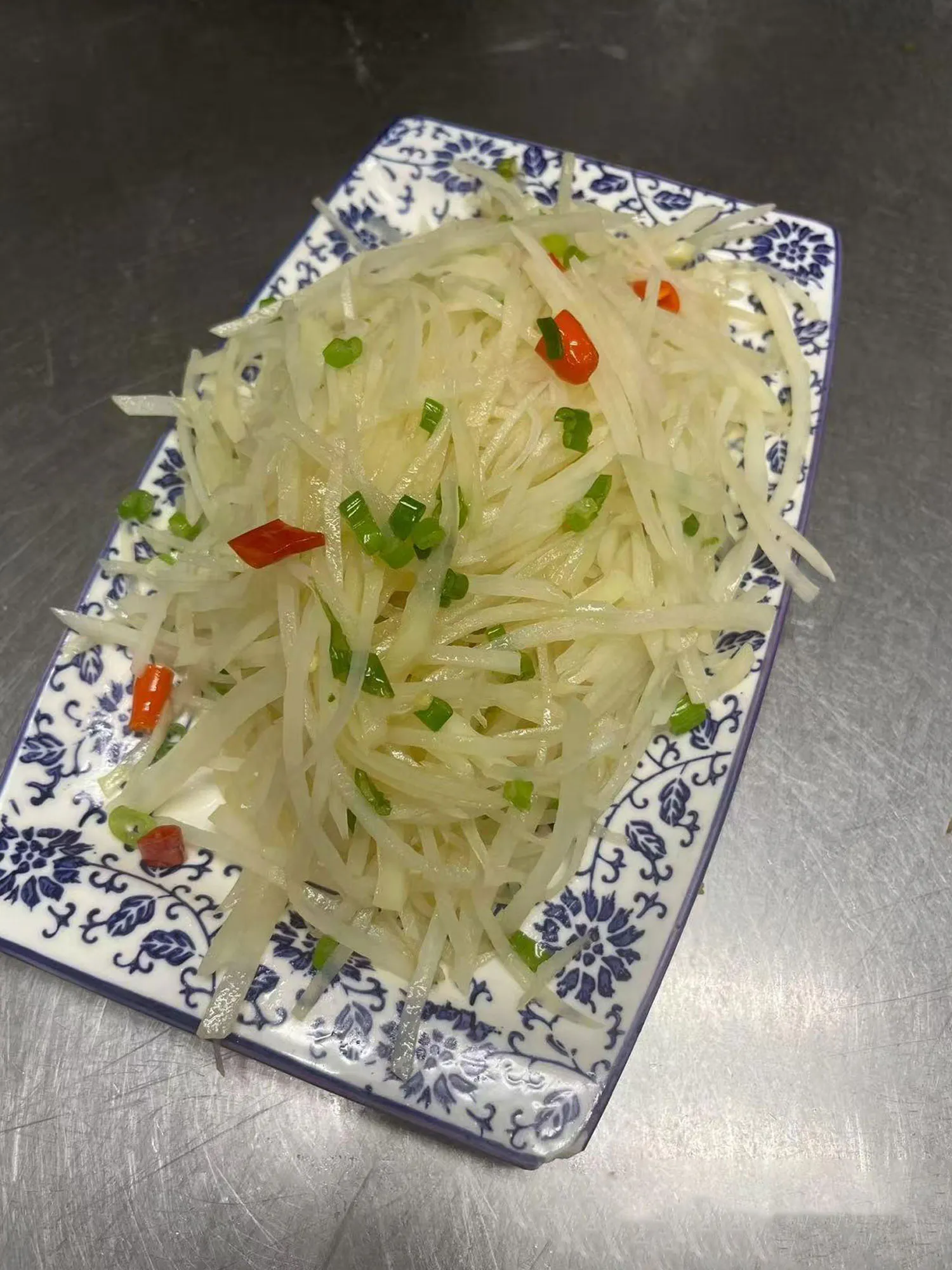 Shredded potato salad with scallions and red chili peppers on a blue-white plate at ShangWei Szechuan, a Chinese Restaurant in Bethlehem