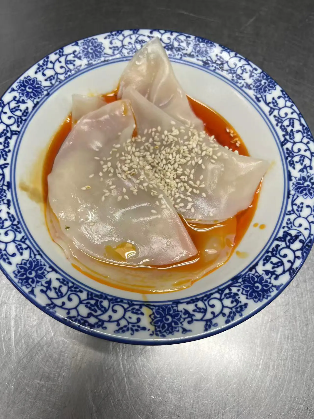 Steamed shrimp dumplings with sesame seeds in spicy red sauce at ShangWei Szechuan, a Chinese Restaurant in Bethlehem
